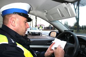 policjant dokumentuje kontrolę drogową
