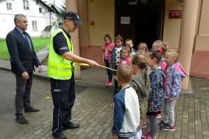 policjant rozdaje dzieciom odblaski