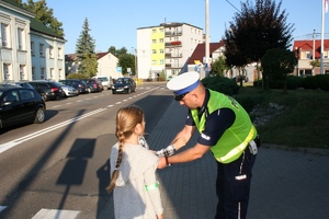 policjant zakłada dziecku odblask