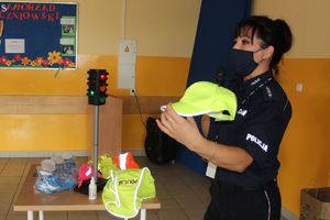 policjantka prezentuje czapeczkę odblaskową