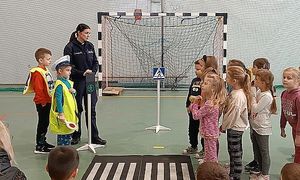 policjantka uczy dzieci przekraczania jezdni