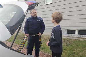 policjant pokazuje chłopcu kolcztkę