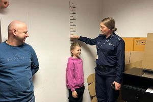policjantka sprawdza wzrost chłopca na miarze ściennej
